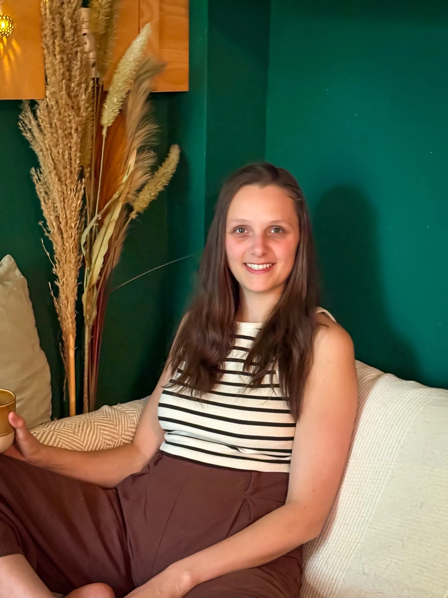 Michelle, Coachin bei CoGether, sitzend mit einer Tasse in der Hand